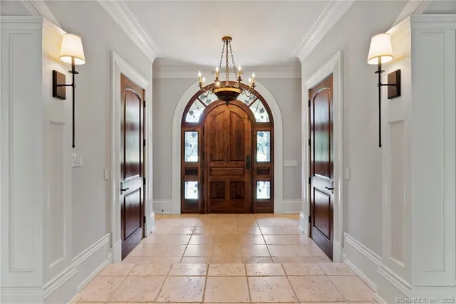 a view of a hallway with entryway chandelier and a living room view