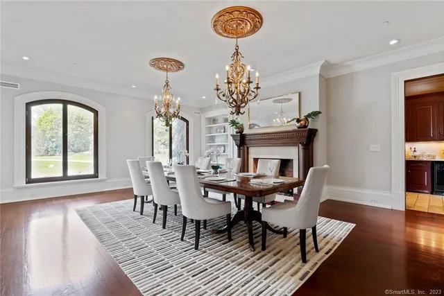 a view of a dining room with furniture a chandelier and wooden floor