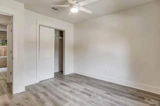 an empty room with wooden floor and closet area