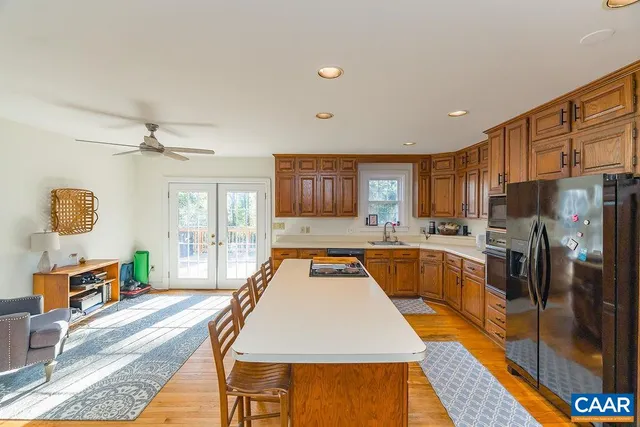 a large kitchen with stainless steel appliances granite countertop a refrigerator stove top oven and a sink