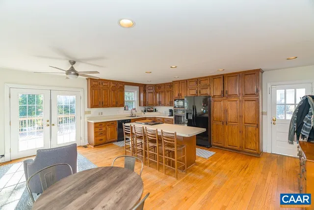 a living room with stainless steel appliances kitchen island granite countertop furniture and a wooden floor