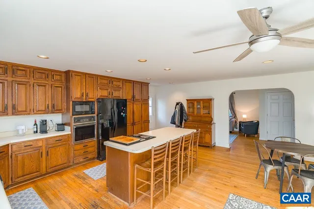 a living room with furniture a rug and kitchen view