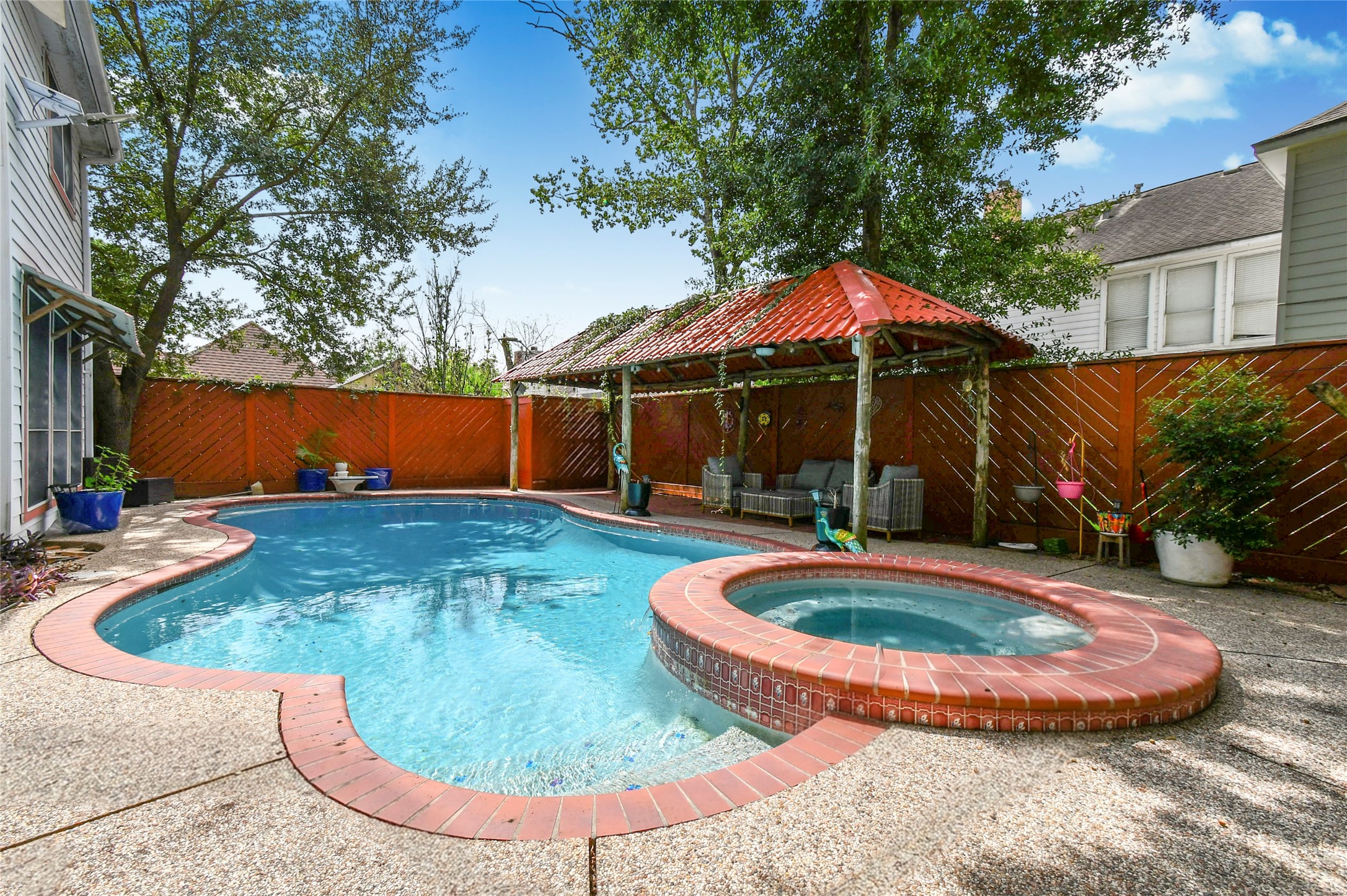 17311 Rothko Lane Spring, TX 77379 - Photo 6 of 37 A charming backyard oasis featuring a sparkling pool and adjoining spa, complemented by a cozy pergola-covered seating area, perfect for relaxation and entertaining.