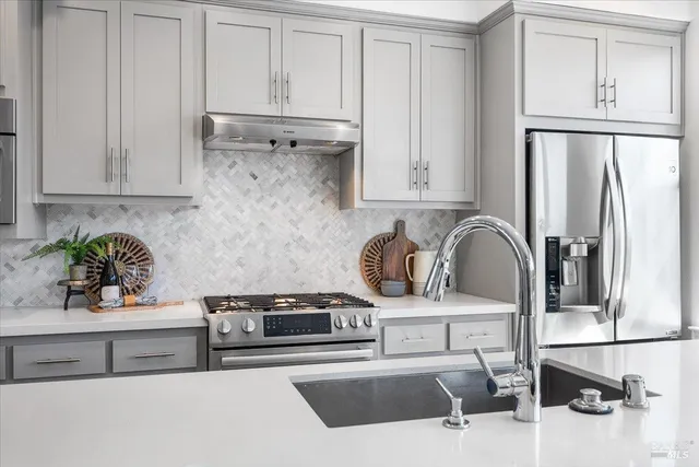 a kitchen with a dining table chairs refrigerator and cabinets