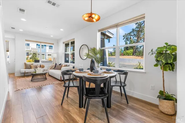 a kitchen with a dining table chairs refrigerator and cabinets