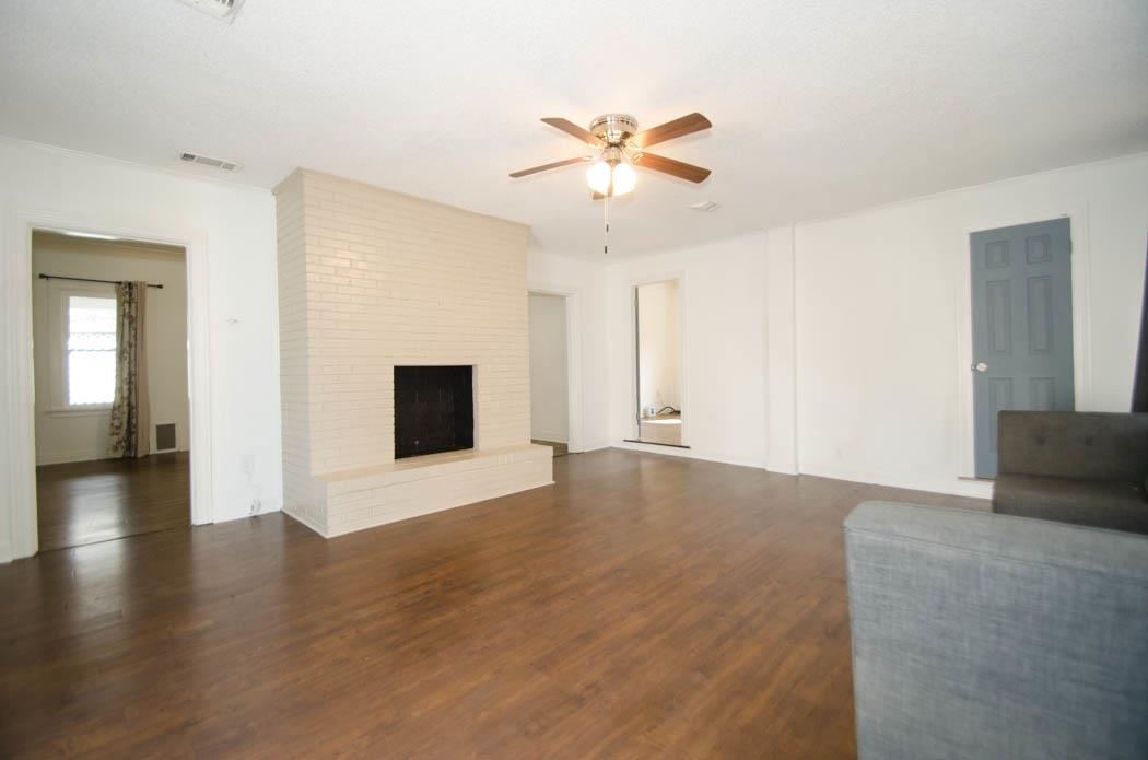 4572 Princeton Road Memphis, TN 38117 - Photo 5 of 24 Unfurnished living room featuring a ceiling fan, dark wood-style floors, and a fireplace