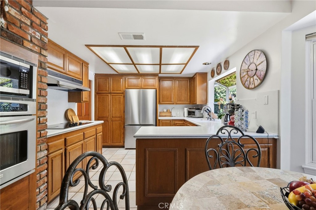18233 Charlton Lane Porter Ranch, CA 91326 - Photo 37 of 40 a view of a kitchen with a table and a stove
