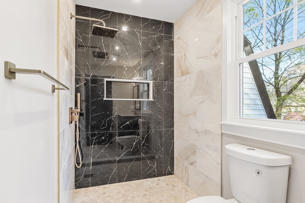 896 Main Street Reading, MA 01867 - Photo 32 of 41 a bathroom with a granite countertop shower a mirror and a sink