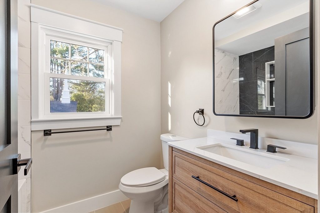896 Main Street Reading, MA 01867 - Photo 35 of 41 a bathroom with a sink vanity granite toilet and a mirror