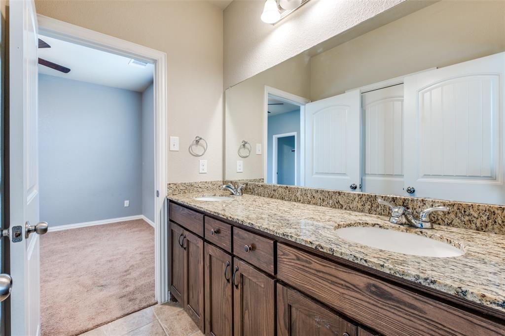 4662 Ralph Lane Dallas, TX 75227 - Photo 21 of 25 Double vanity with undermount sinks, granite countertops, and wood-finish cabinetry