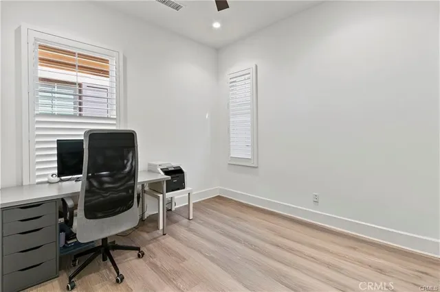 a view of a workspace with furniture and a window