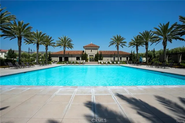 a view of a swimming pool with lawn chairs under an umbrella