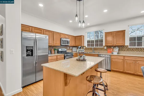 a kitchen with stainless steel appliances granite countertop a sink stove and refrigerator