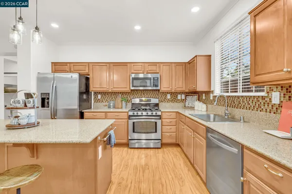 a kitchen with stainless steel appliances granite countertop a sink a stove and a refrigerator