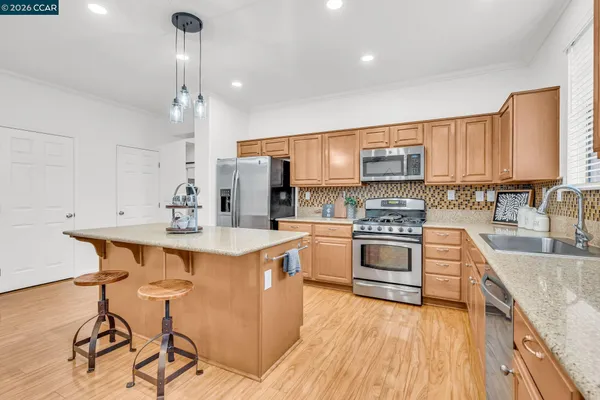 a kitchen with a stove and a wooden floor