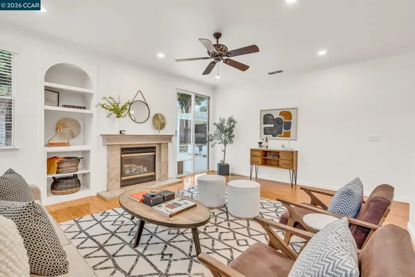 a living room with fireplace furniture and a large window