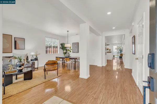 a kitchen with stainless steel appliances granite countertop a stove top oven a refrigerator a sink and a dining table with wooden floor