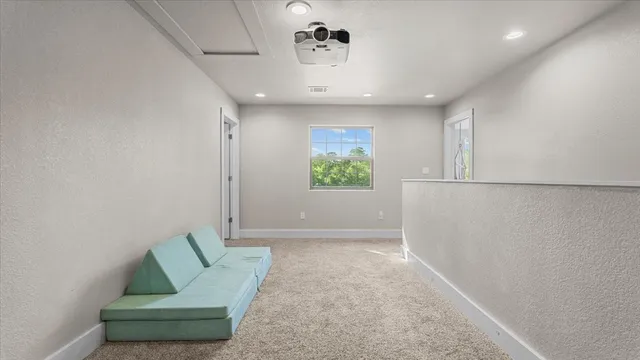 a view of a big room with a chandelier fan and windows