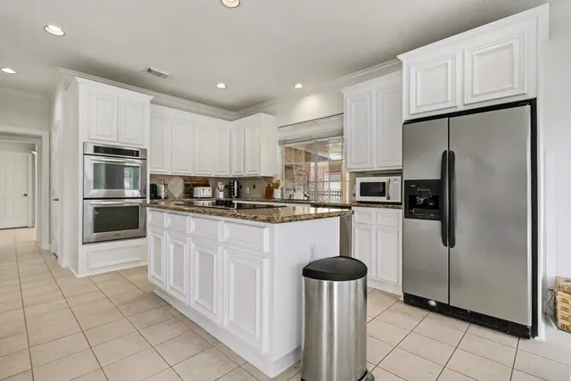 a kitchen with white cabinets and sink