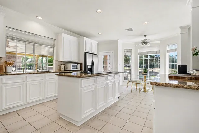 a kitchen with granite countertop white cabinets white appliances and granite counter tops