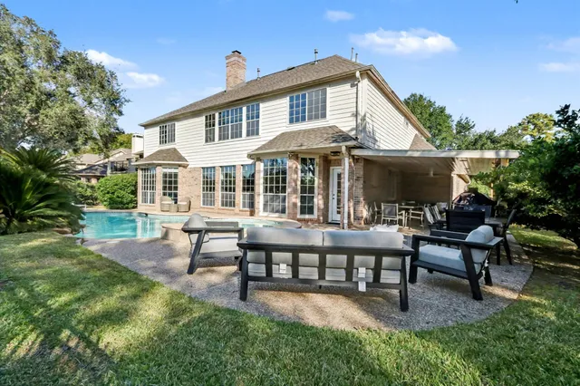 a view of a house with pool fire pit and sitting area