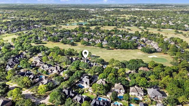 an aerial view of residential houses with outdoor space and trees
