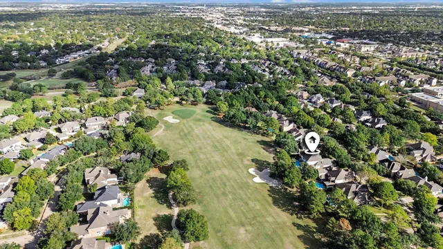 an aerial view of residential houses with outdoor space and trees