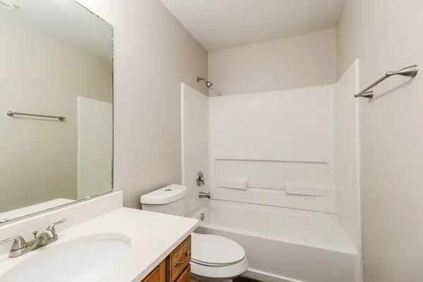 an empty room with wooden floor and a ceiling fan