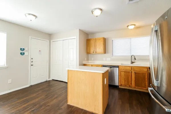an empty room with wooden floor fan and windows