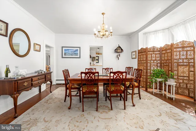 a view of a dining room and livingroom with furniture window and wooden floor