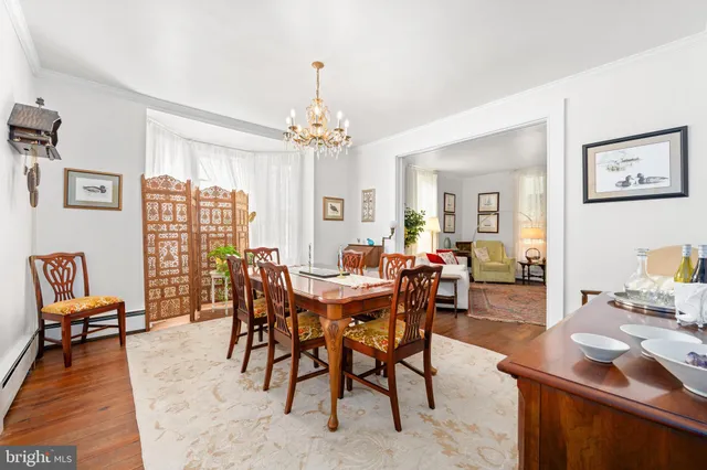 a dining room with furniture a chandelier and wooden floor