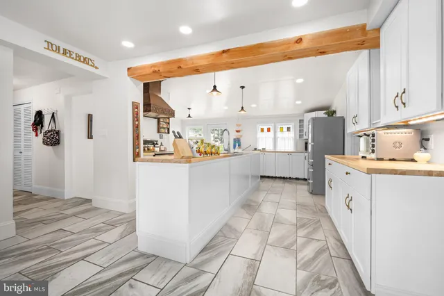a kitchen with stainless steel appliances kitchen island granite countertop a refrigerator and a sink