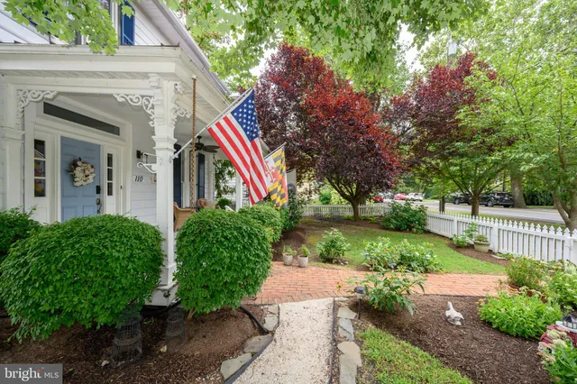 a view of a house with a yard and large trees