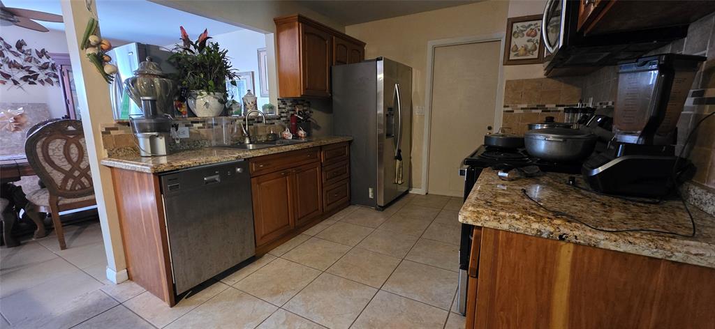 9522 Affirmed Lane Boca Raton, FL 33496 - Photo 3 of 10 a kitchen with stainless steel appliances granite countertop a sink stove and refrigerator