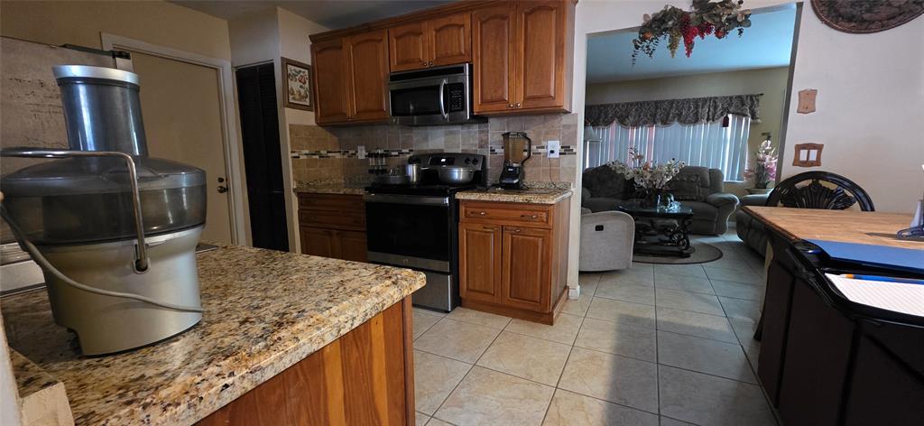 9522 Affirmed Lane Boca Raton, FL 33496 - Photo 4 of 10 a kitchen with granite countertop a sink a stove and refrigerator