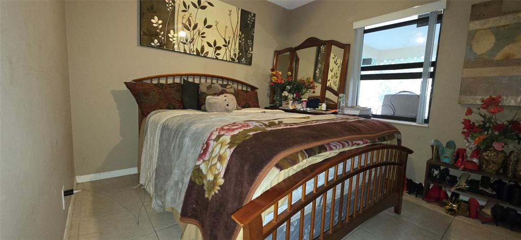 9522 Affirmed Lane Boca Raton, FL 33496 - Photo 7 of 10 a bedroom with a bed and a painting on the wall