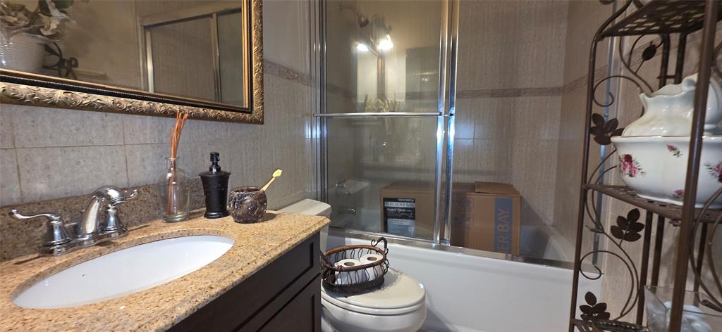 9522 Affirmed Lane Boca Raton, FL 33496 - Photo 8 of 10 a bathroom with a granite countertop sink a toilet and a mirror