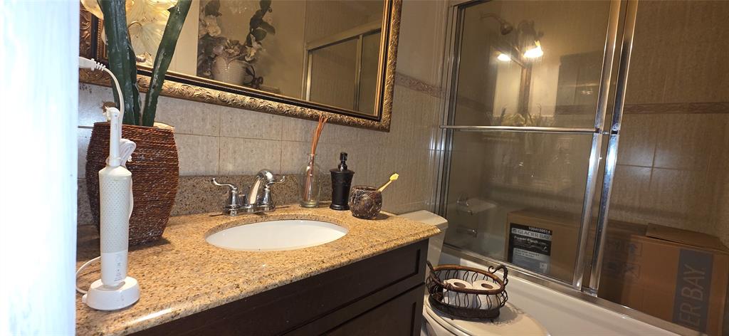 9522 Affirmed Lane Boca Raton, FL 33496 - Photo 9 of 10 a bathroom with a granite countertop sink a toilet and a mirror