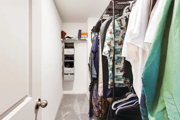 a view of walk in closet with clothes and shoes