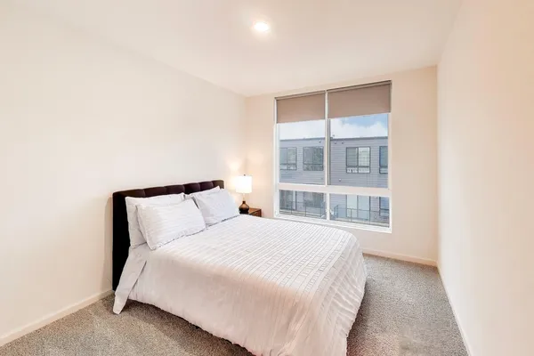 a large bed sitting in a bedroom next to a window