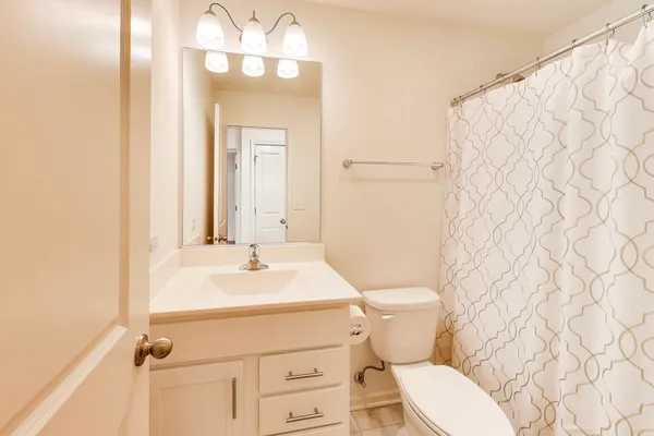 a bathroom with a sink mirror vanity and toilet
