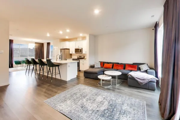 a living room with furniture and view of kitchen