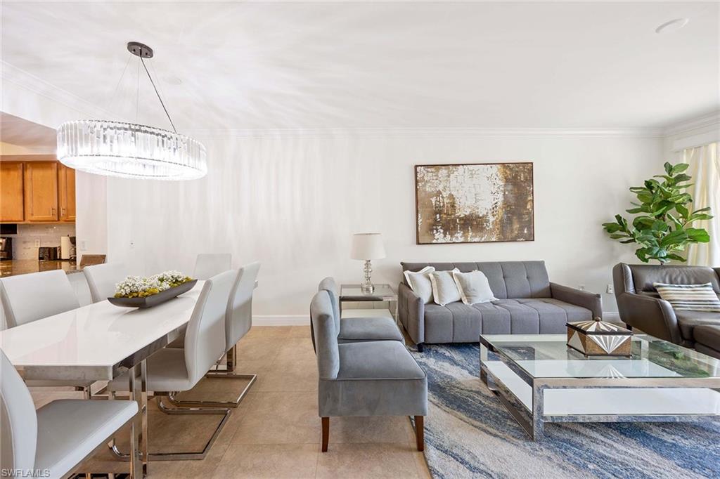 5455 Worthington Lane, Unit 103 Naples, FL 34110 - Photo 12 of 38 a living room with furniture and a chandelier