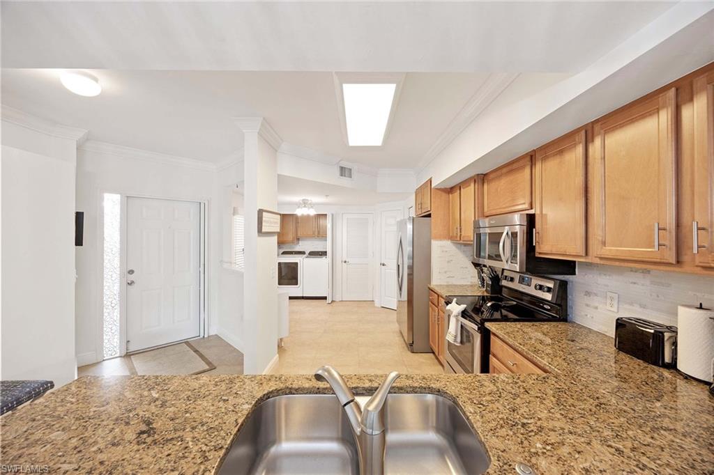 5455 Worthington Lane, Unit 103 Naples, FL 34110 - Photo 15 of 38 a bedroom with furniture and a flat screen tv