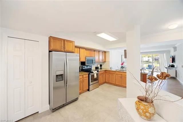 a kitchen with stainless steel appliances a refrigerator a stove a dining table and chairs