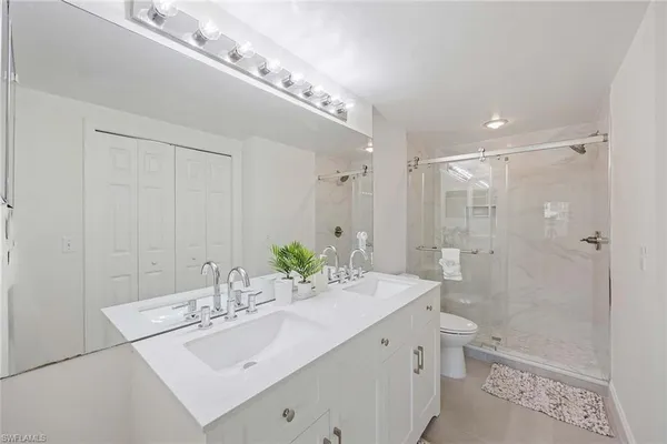 a bathroom with a double vanity sink mirror double and toilet