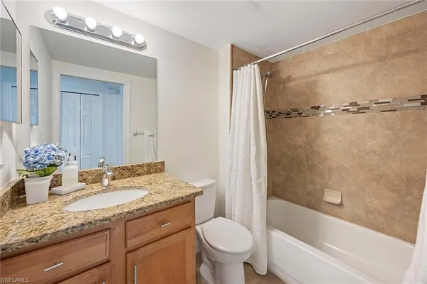 a bathroom with a granite countertop sink toilet and shower