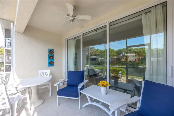a living room with furniture a table and a large window
