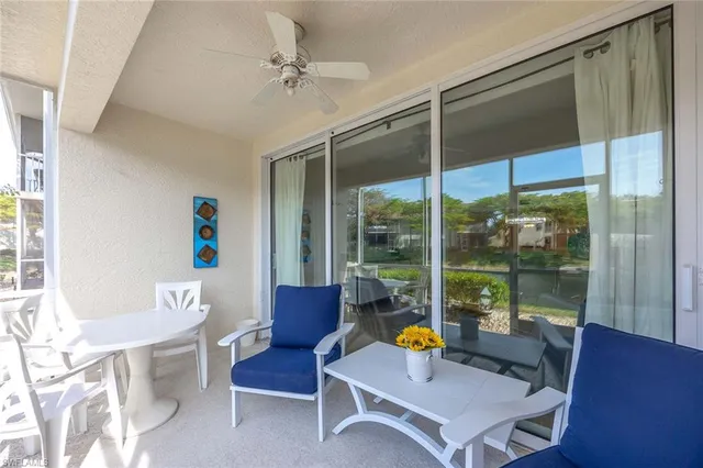 a living room with furniture a table and a large window