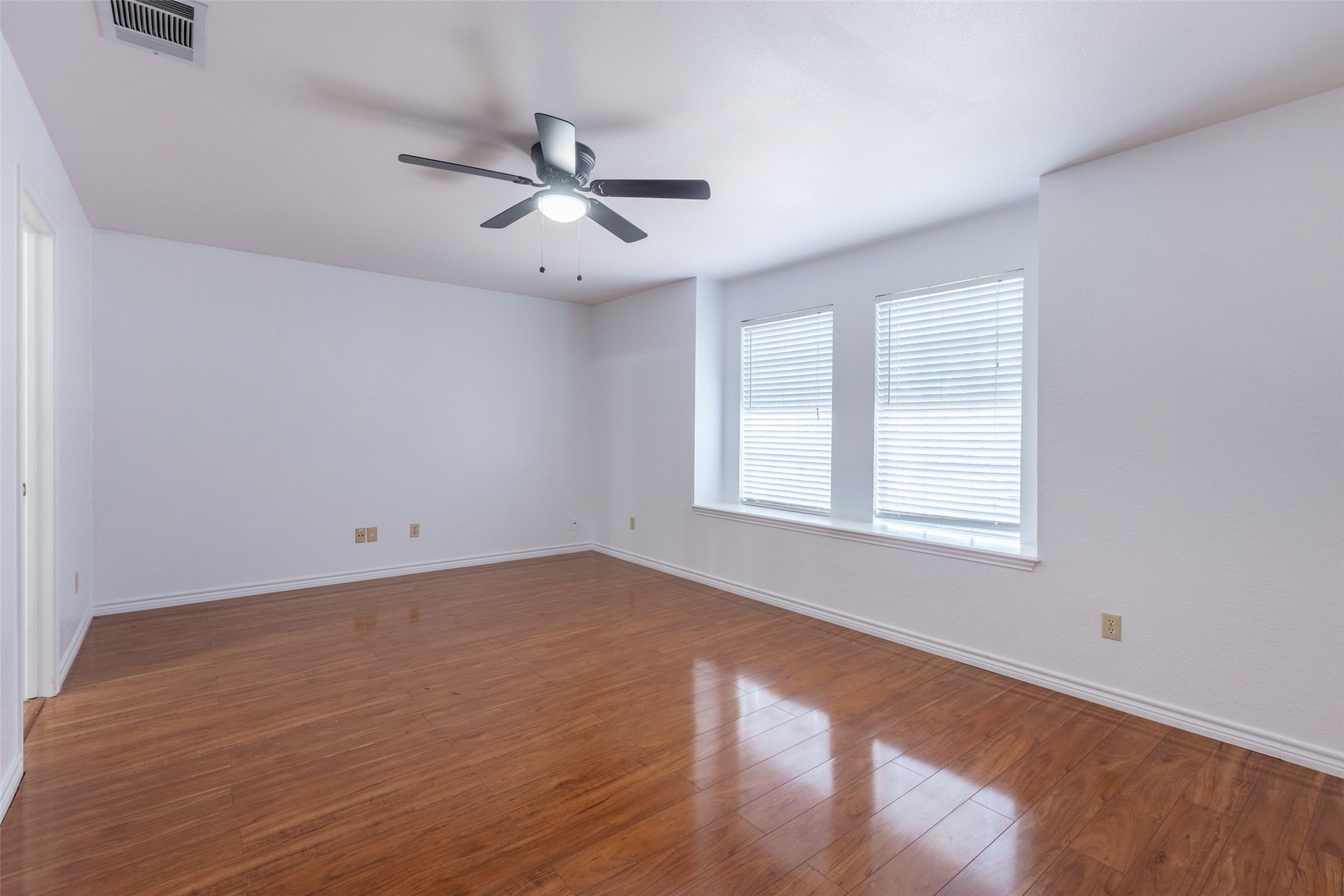 8506 Bisbee Court Austin, TX 78745 - Photo 15 of 20 Spacious room featuring wood-finish flooring and a ceiling fan